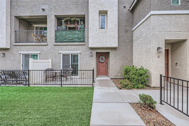 doorway to property with stucco siding and a lawn