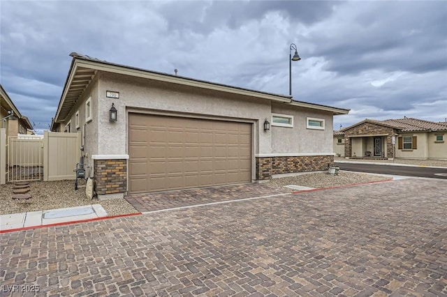 790 Sunny Sagebrush St, Henderson, NV 89011 - exterior space with brick siding, fence, decorative driveway, a garage, and stucco siding