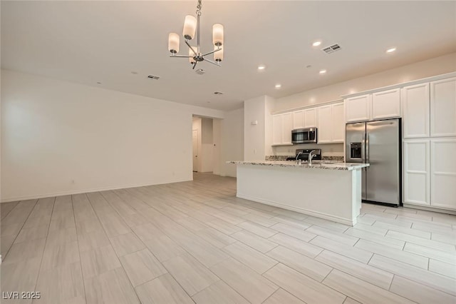 790 Sunny Sagebrush St, Henderson, NV 89011 - kitchen with an inviting chandelier, stainless steel appliances, white cabinetry, visible vents, and light stone countertops