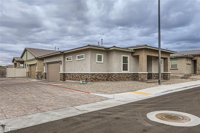 790 Sunny Sagebrush St, Henderson, NV 89011 - view of front facade featuring stucco siding, an attached garage, fence, and decorative driveway