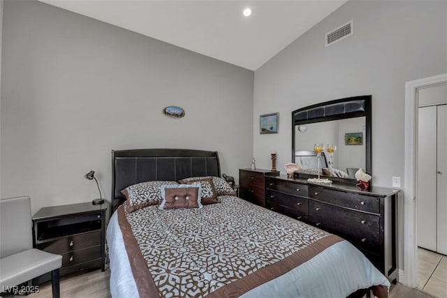 bedroom with visible vents and high vaulted ceiling