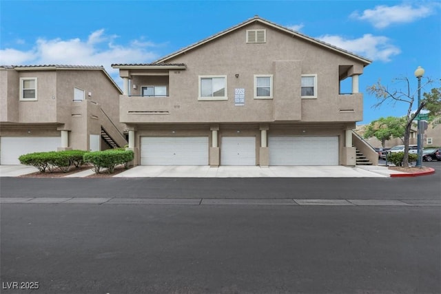 view of front of home featuring stairs, stucco siding, and a garage