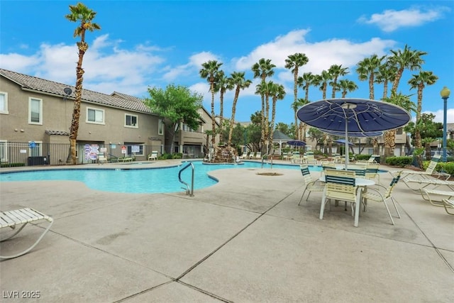 pool with a patio and fence