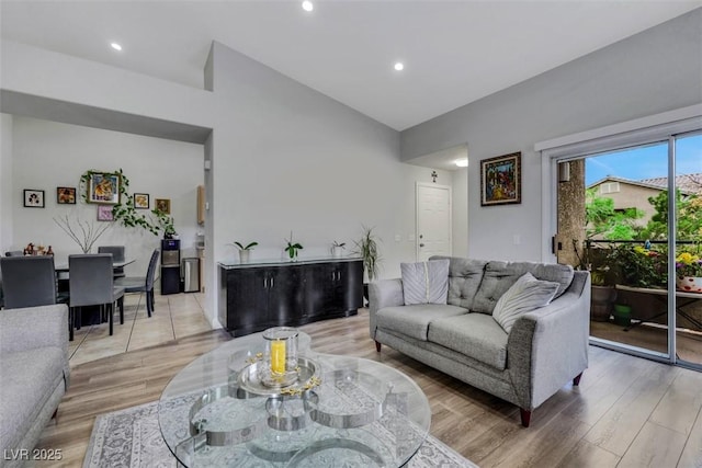 living room with light wood-style floors, vaulted ceiling, and recessed lighting