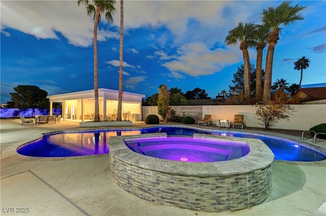 view of pool featuring a patio, a pool with connected hot tub, and fence