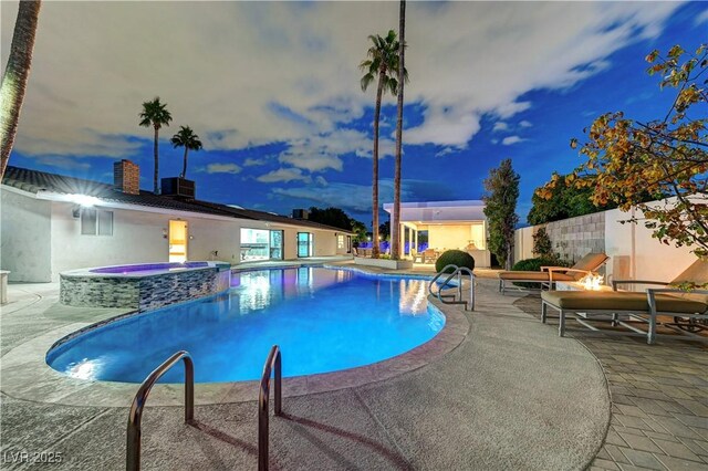view of swimming pool with a patio, a pool with connected hot tub, and fence