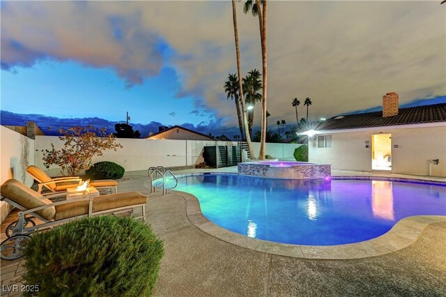 view of pool featuring an outdoor fire pit, a patio area, a pool with connected hot tub, and a fenced backyard