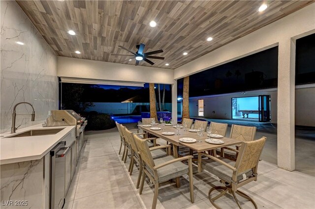 view of patio with a sink, area for grilling, a grill, outdoor dining space, and ceiling fan