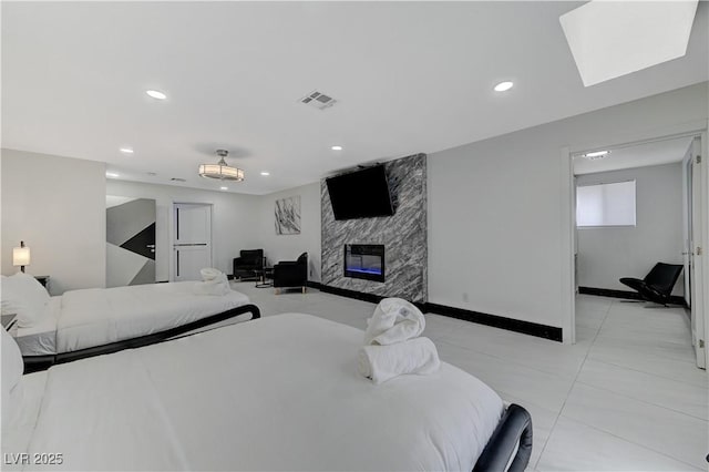 bedroom with a large fireplace, recessed lighting, light tile patterned flooring, and baseboards