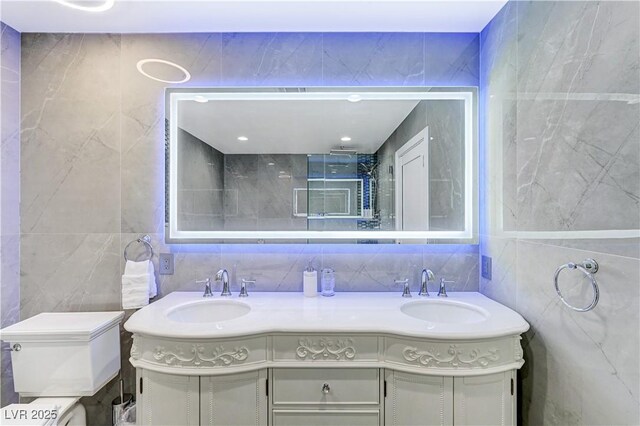 bathroom with tile walls and double vanity
