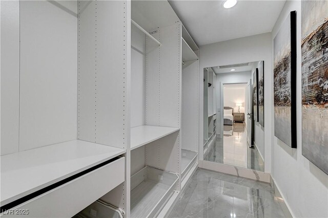 walk in closet with light marble finish flooring