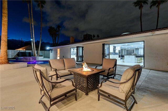 patio at twilight featuring an outdoor living space with a fire pit