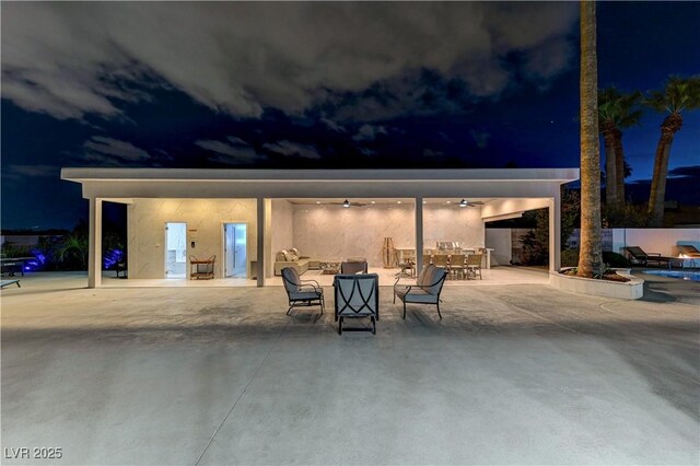 patio at twilight featuring ceiling fan and outdoor dining space