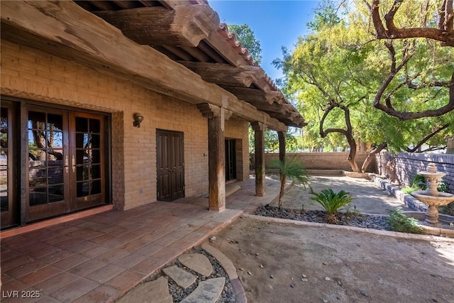 view of patio featuring french doors and fence