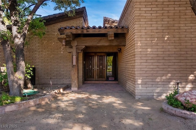 doorway to property featuring french doors and brick siding