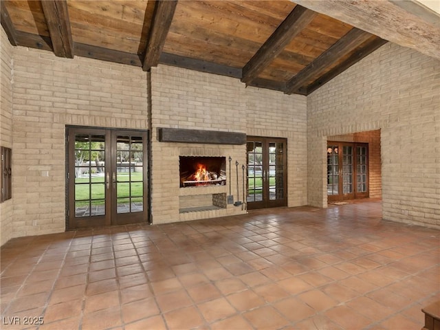 unfurnished living room with wood ceiling, french doors, and beam ceiling