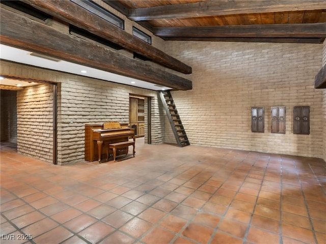 interior space with brick wall, wooden ceiling, and tile patterned floors