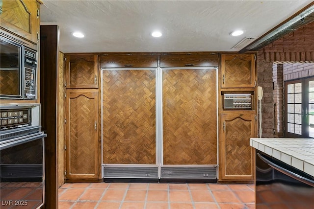 room details featuring wall oven, built in microwave, tile countertops, recessed lighting, and dishwasher