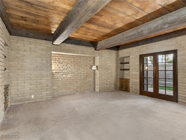 carpeted empty room featuring wooden ceiling, french doors, beam ceiling, and brick wall