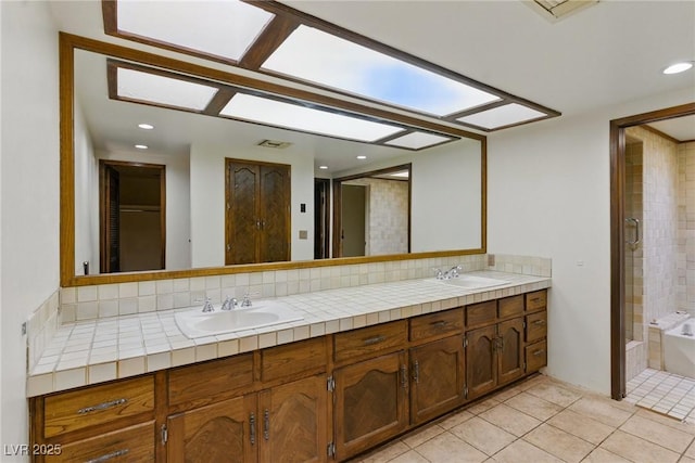 full bathroom featuring a bathtub, tile patterned floors, tasteful backsplash, and a sink