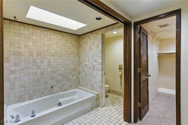 full bathroom with toilet, a skylight, visible vents, tile patterned floors, and a bath
