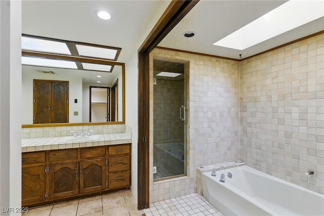 bathroom featuring a skylight, vanity, visible vents, tile patterned floors, and a shower stall