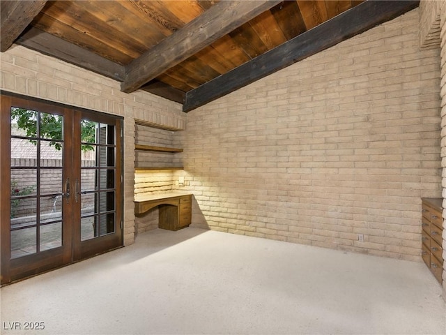 interior space featuring wood ceiling, french doors, vaulted ceiling with beams, and brick wall