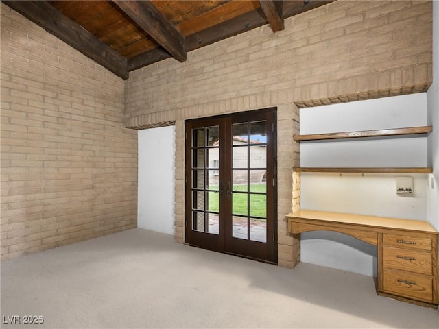 interior space featuring carpet, french doors, beam ceiling, brick wall, and wooden ceiling