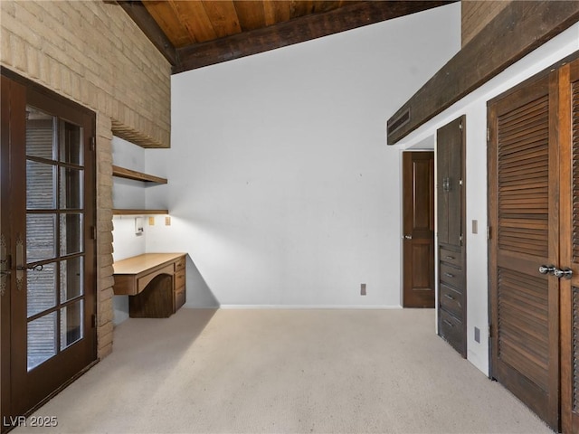 interior space with wooden ceiling, beamed ceiling, and baseboards