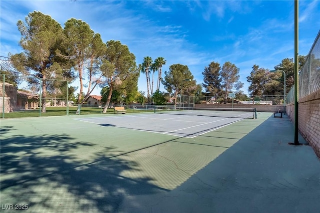 view of tennis court featuring fence and community basketball court