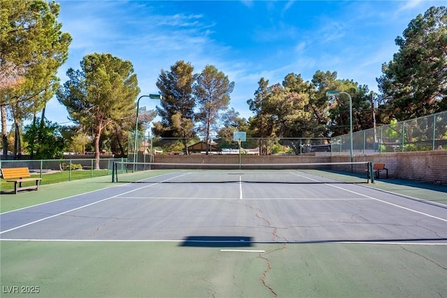 view of tennis court featuring fence and community basketball court