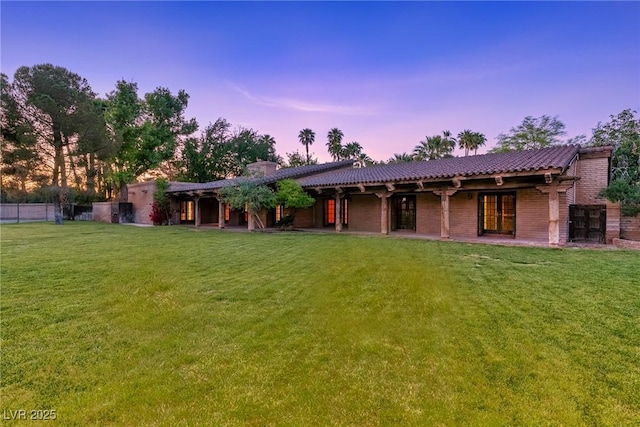 view of front of home featuring a chimney, fence, and a front yard