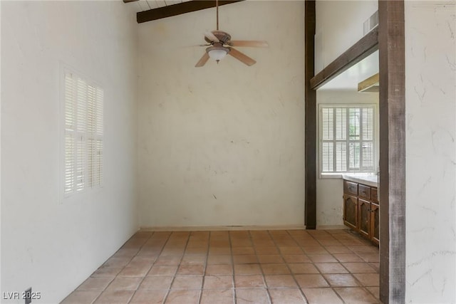 empty room featuring beamed ceiling, ceiling fan, and high vaulted ceiling
