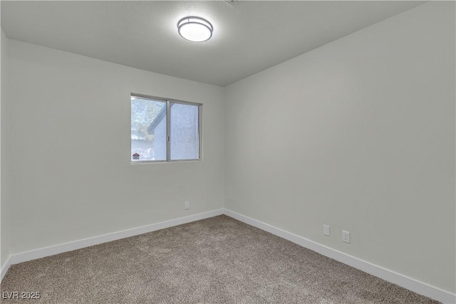 unfurnished room with carpet floors and baseboards