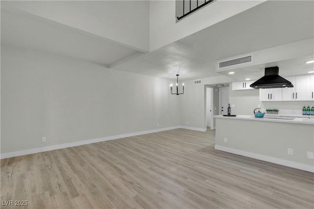 unfurnished living room with an inviting chandelier, visible vents, light wood-style flooring, and baseboards