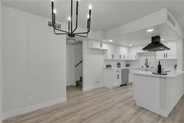kitchen with stainless steel dishwasher, island range hood, baseboards, and visible vents