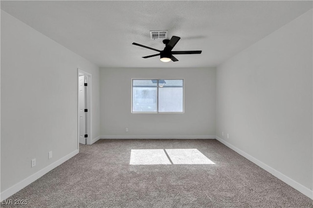 carpeted empty room with ceiling fan, baseboards, and visible vents