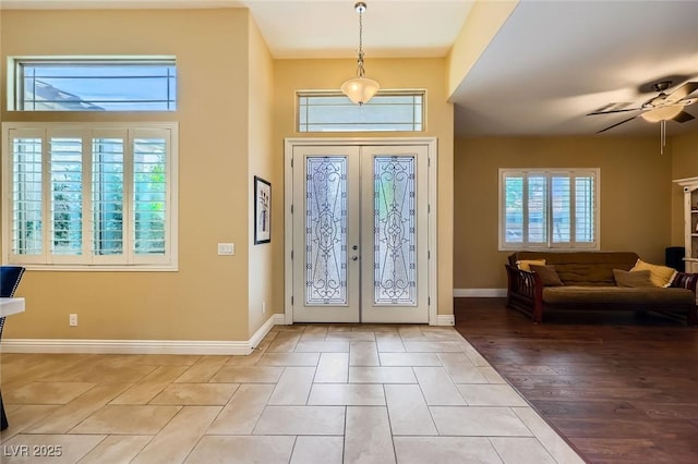 entryway with a ceiling fan, french doors, and baseboards