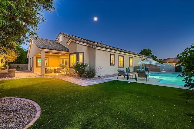 rear view of property with an outdoor hangout area, a patio, and stucco siding