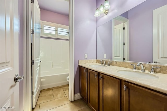 bathroom featuring tile patterned floors, double vanity, toilet, bathtub / shower combination, and baseboards