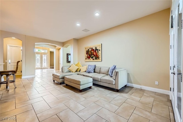 living room featuring arched walkways, french doors, recessed lighting, baseboards, and light tile patterned flooring
