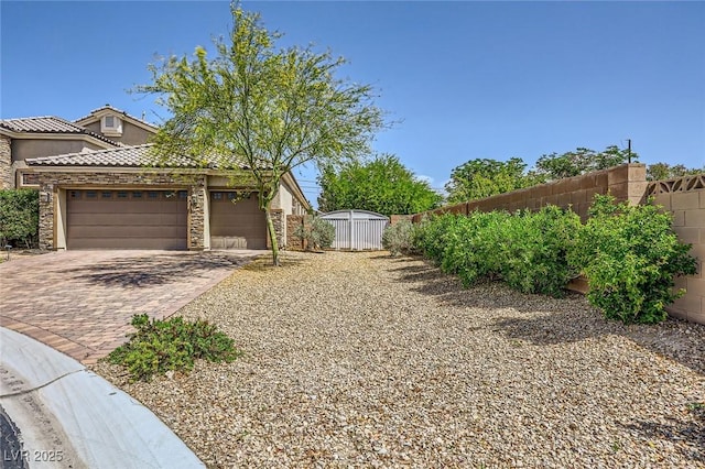view of yard featuring fence, driveway, and an attached garage