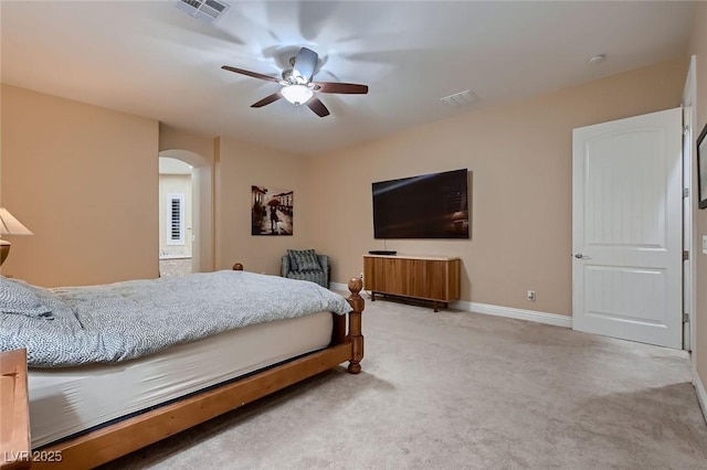 bedroom featuring arched walkways, light colored carpet, ceiling fan, and baseboards