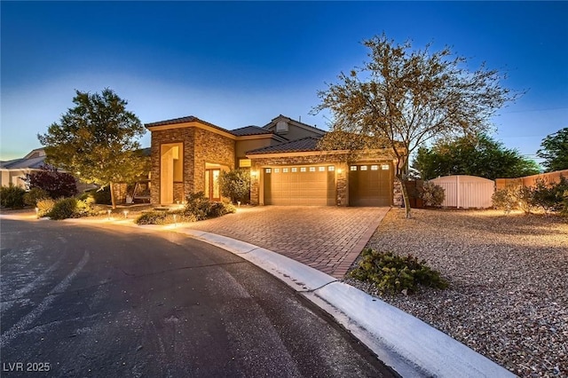 7418 Lawrence Powers Ct, Las Vegas, NV 89129 - view of front of home with stone siding, an attached garage, driveway, and a tile roof
