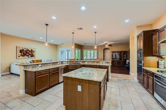 7418 Lawrence Powers Ct, Las Vegas, NV 89129 - kitchen with stainless steel appliances, a spacious island, a sink, recessed lighting, and decorative light fixtures