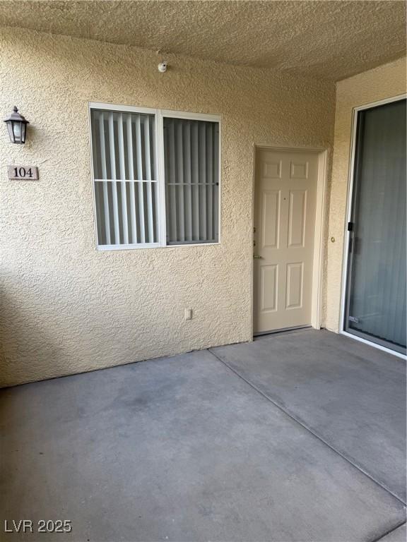 doorway to property with a patio and stucco siding