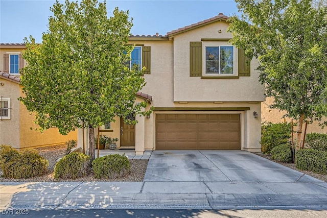 view of front facade featuring driveway, stucco siding, a tiled roof, and a garage