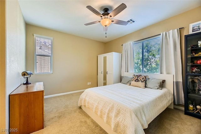 carpeted bedroom featuring multiple windows, visible vents, baseboards, and a ceiling fan