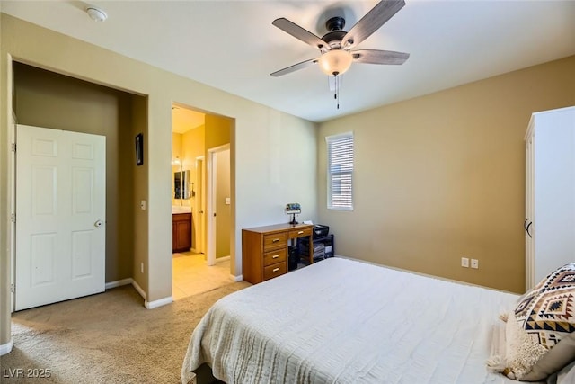 bedroom with baseboards, ensuite bathroom, ceiling fan, and light colored carpet