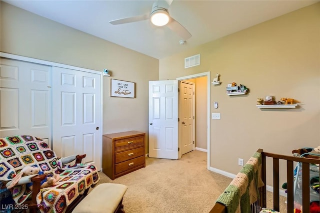 bedroom featuring a closet, baseboards, ceiling fan, visible vents, and light carpet
